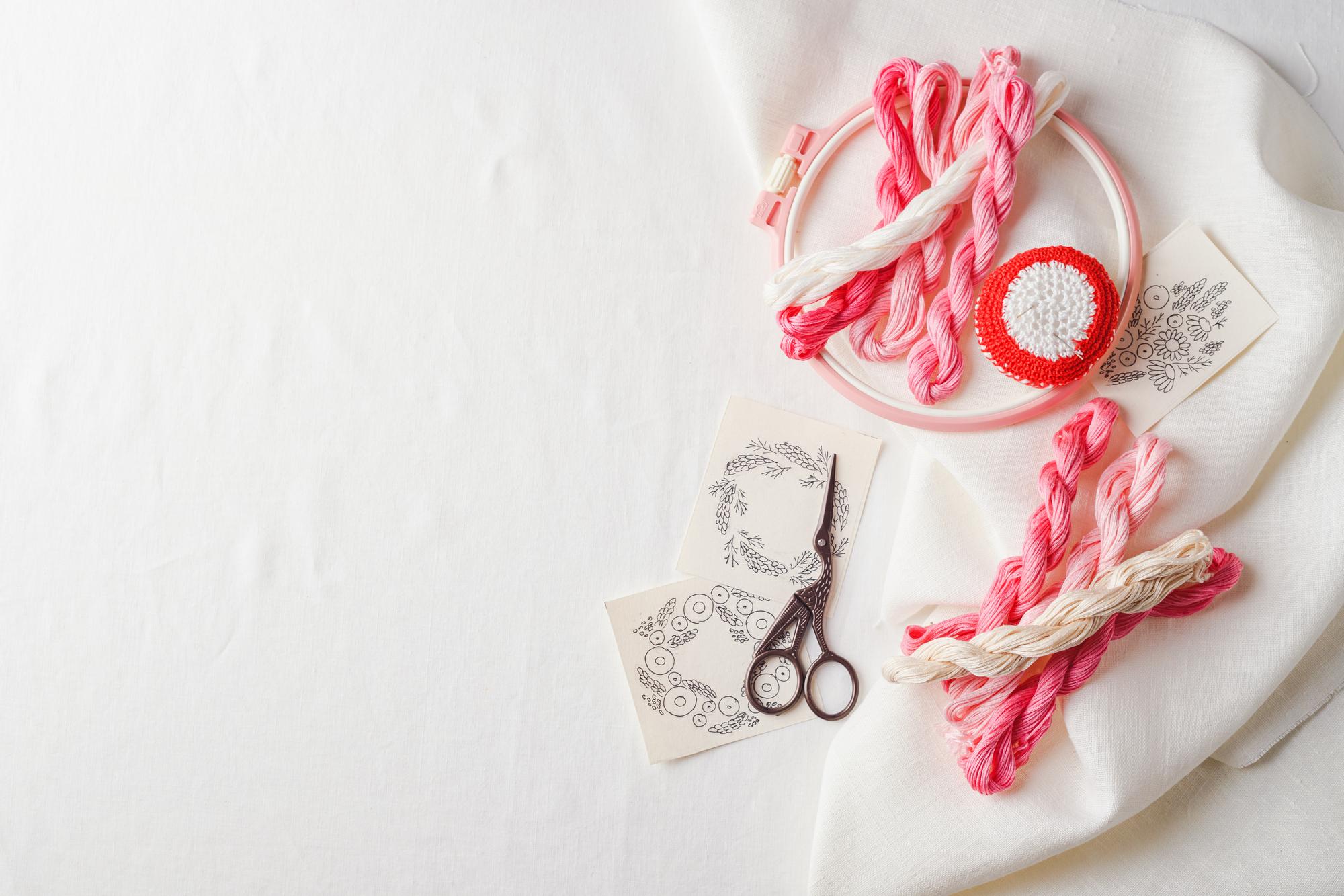 Hands arranging embroidered textile in studio